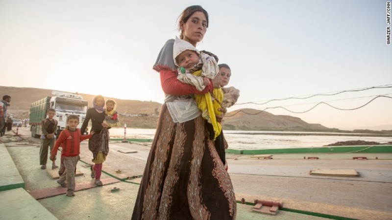 Yazidi woman carrying her child