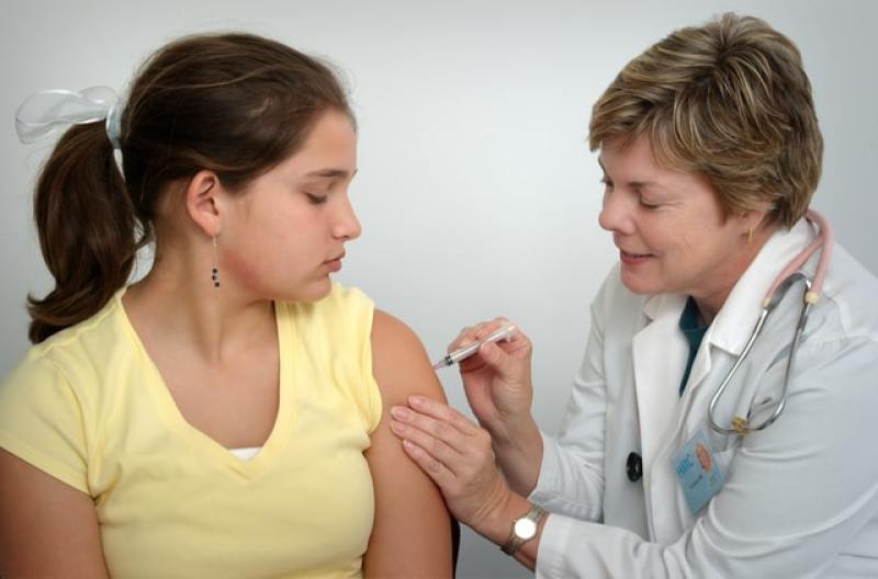 Teen receiving injection from doctor