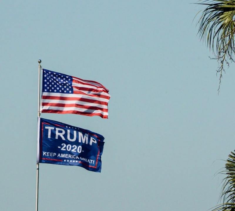 US Flag on a pole alongside President Trump's banner