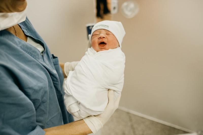 woman carrying newborn baby