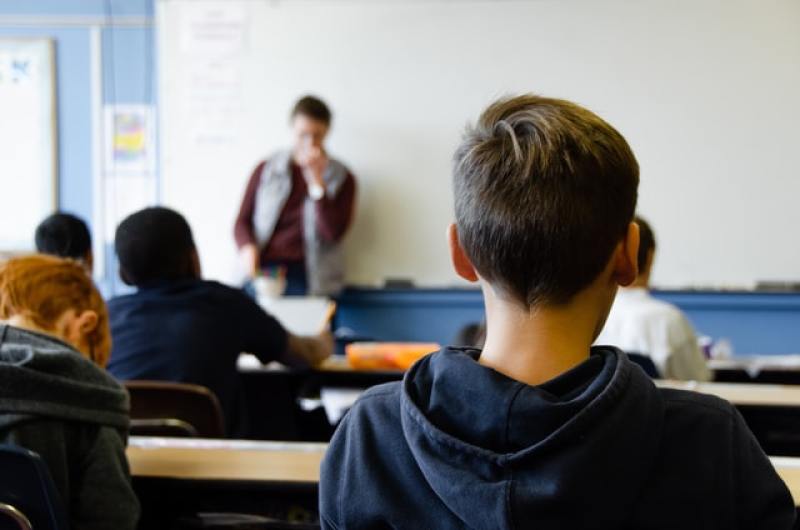 Student listening to teacher in classroom