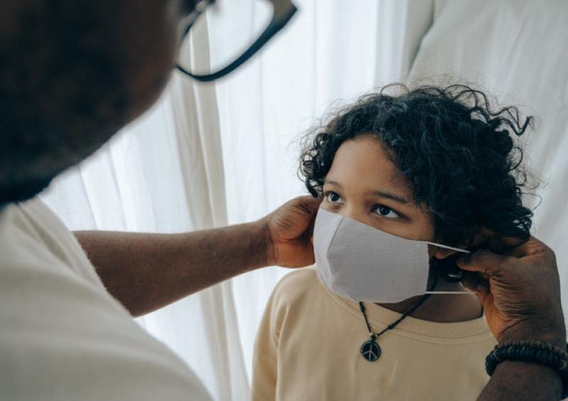 man putting mask on child