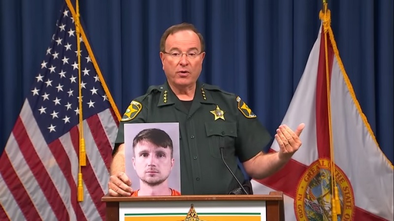 Polk County Sheriff Grady Judd holding photo of disgraced youth pastor Andrew Weaver