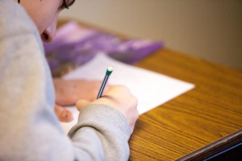 student using a pencil to write or draw on paper