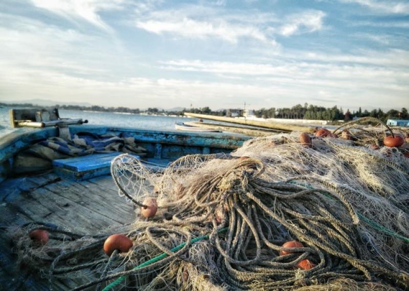 fishing boat with nets scattered around