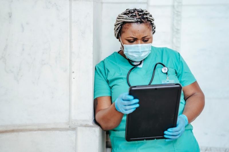 nurse in scrubs holding a file 