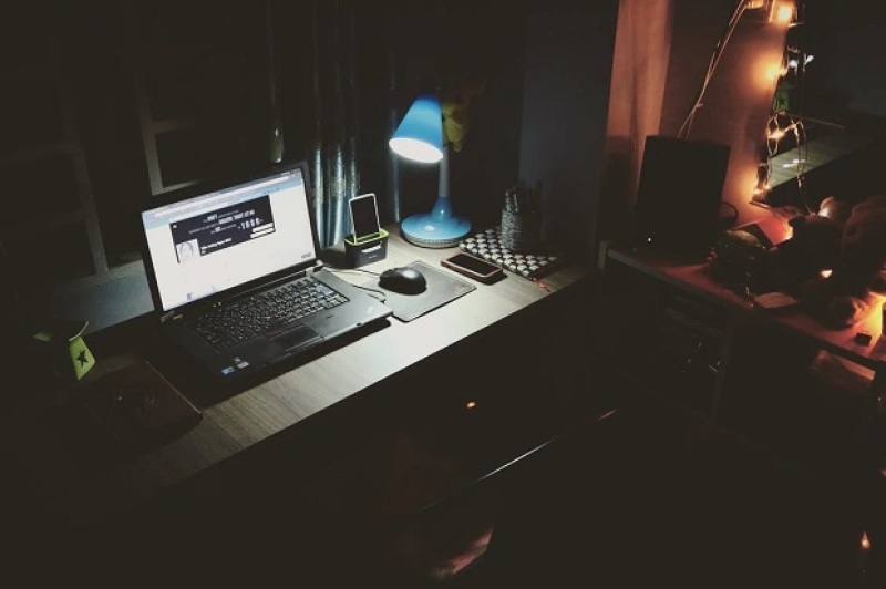 laptop computer in table being used in a dark room at night