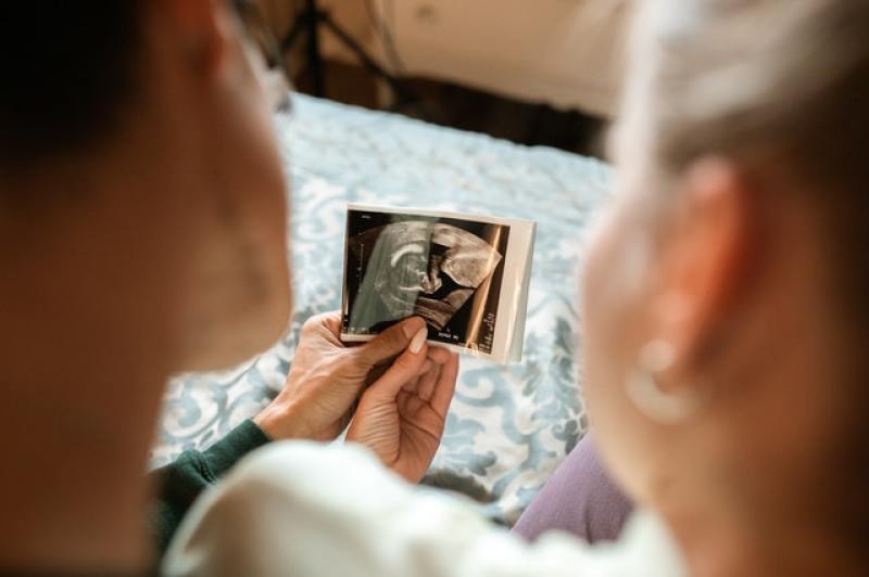 couple looking at their unborn baby via ultrasound image