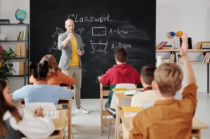 classroom scene where a teacher asks questions and students answer