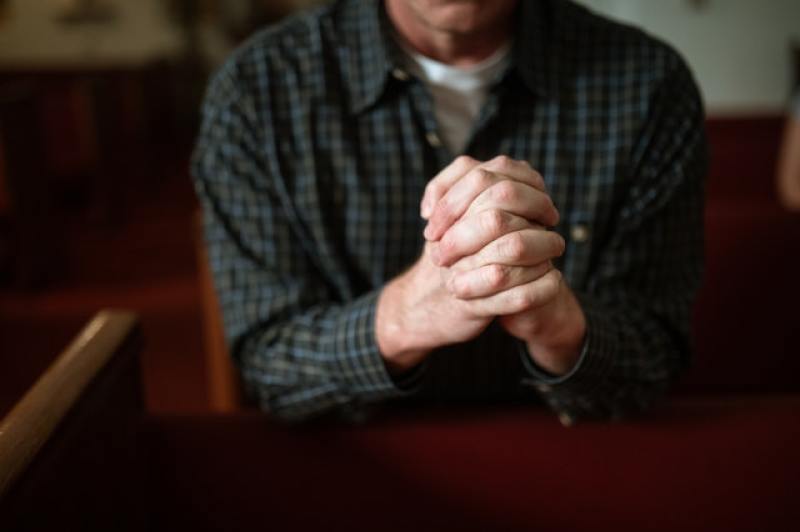 man praying inside church building