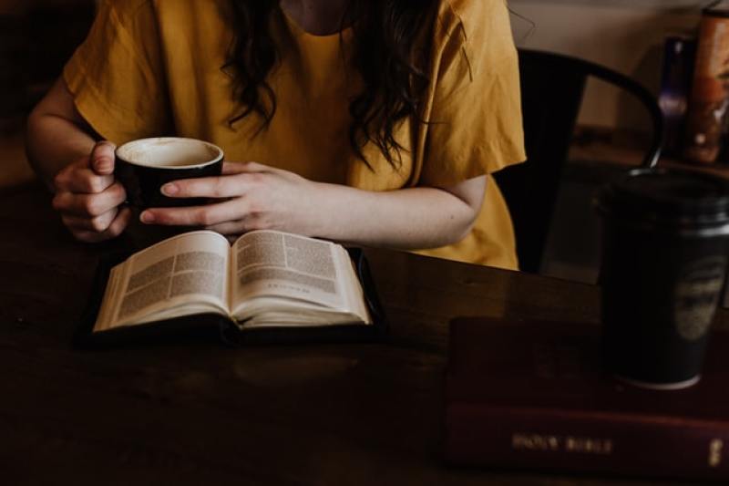 woman having quiet time with her Bible and a cup of drink