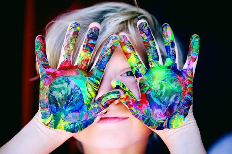child playing with paint on the hands