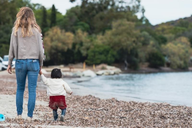 mother walking with her child on the shore