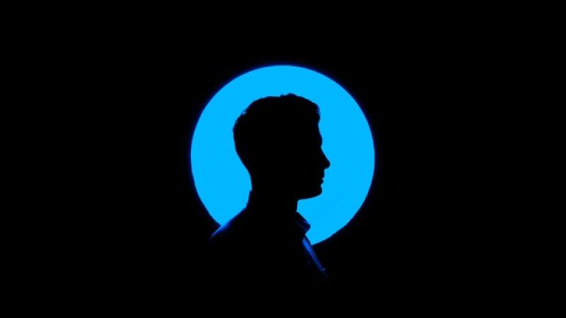silhouette of a man standing in front of a blue lighted ball